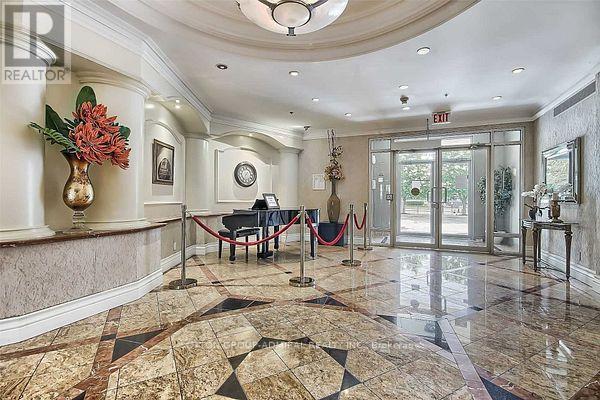 A foyer with a marble floor and a chandelier.