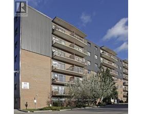 A tall apartment building with balconies and a sign that reads "REALTOR".
