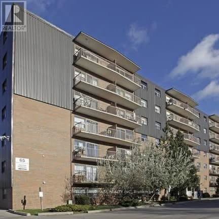 A tall apartment building with balconies and a sign that reads "REALTOR".
