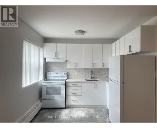 A white kitchen with a stove, oven, and refrigerator.