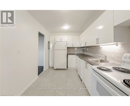 A white kitchen with a stove top oven and a sink.
