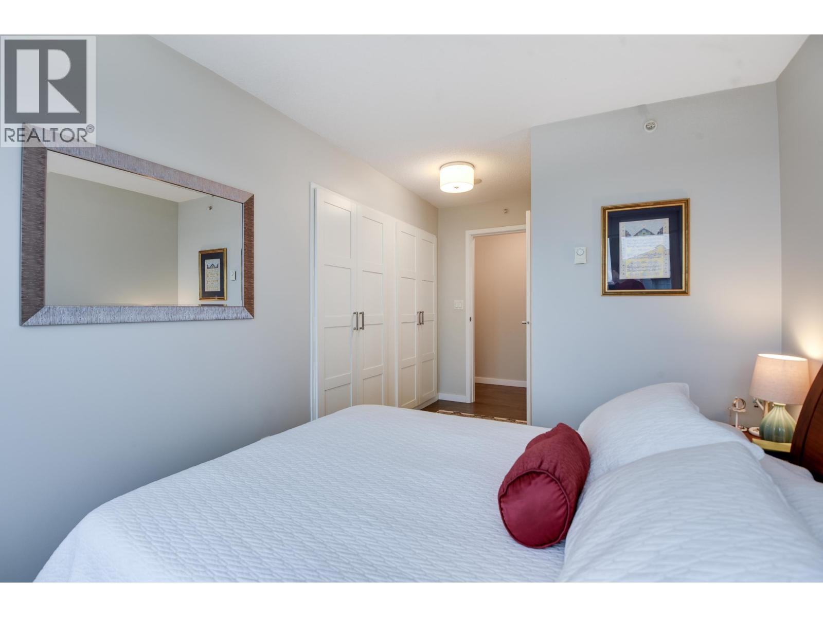 A bedroom with a large bed and a mirror on the wall.