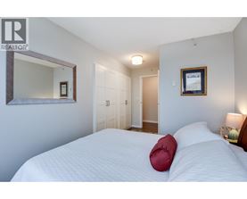 A bedroom with a large bed and a mirror on the wall.