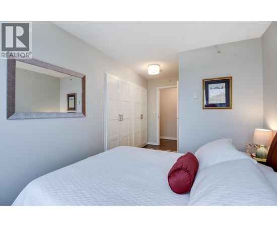 A bedroom with a large bed and a mirror on the wall.