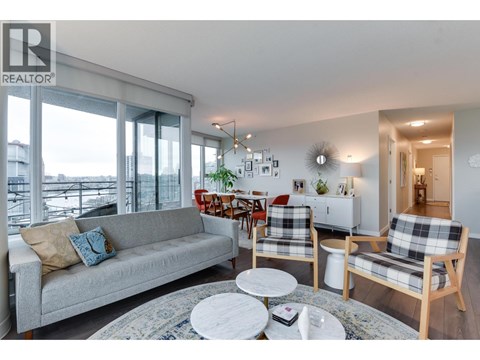 A living room with a grey couch and a white coffee table.