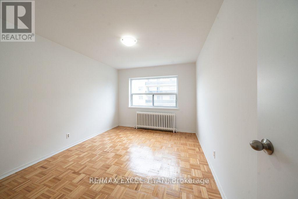 A room with a wooden floor and a window with a white frame.