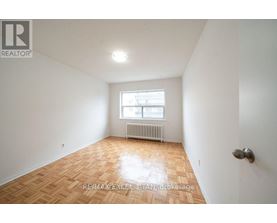 A room with a wooden floor and a window with a white frame.