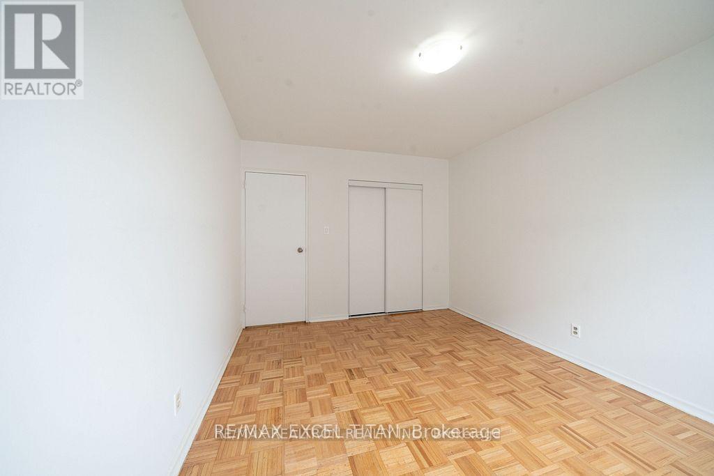 A room with wooden flooring and two doors.