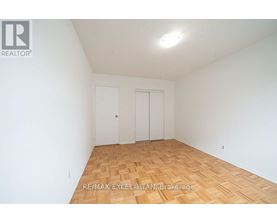 A room with wooden flooring and two doors.