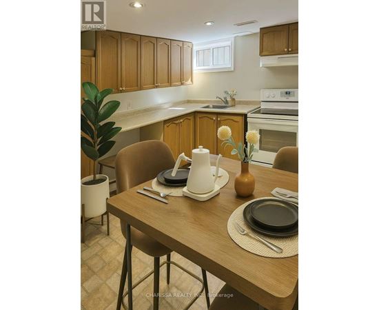 A kitchen with a table set for two with a vase of flowers on it.