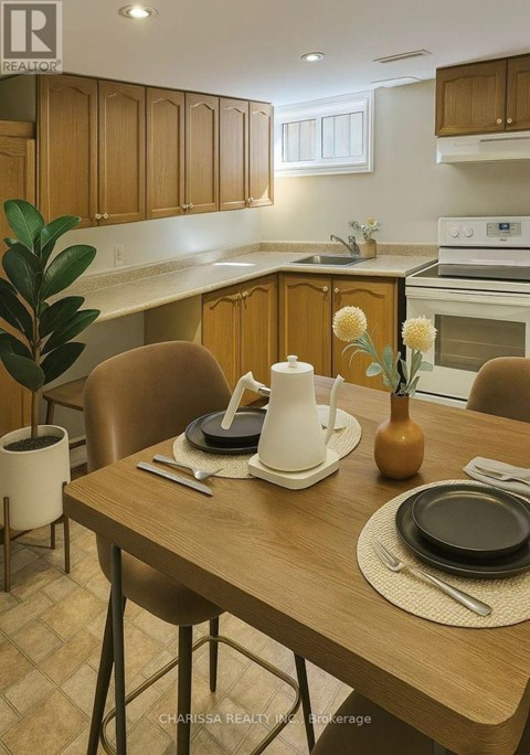 A kitchen with a table set for two with a vase of flowers on it.