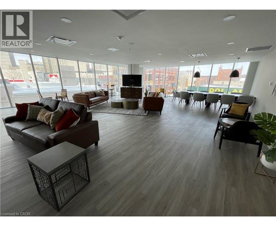 A large, modern living room with a variety of seating options and a flat-screen TV.