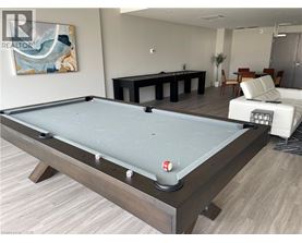 A pool table in a room with a painting on the wall and a sofa in the background.