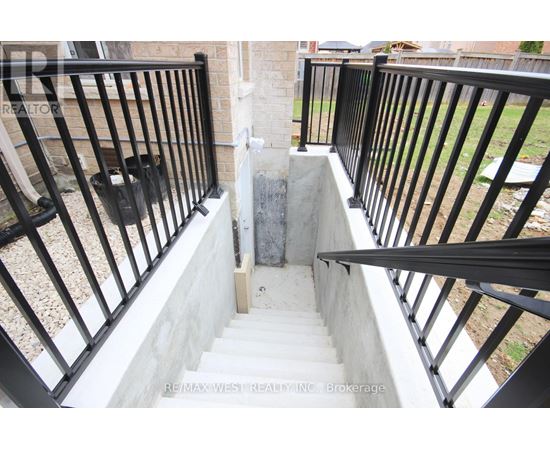 A staircase with a black railing and a concrete step.