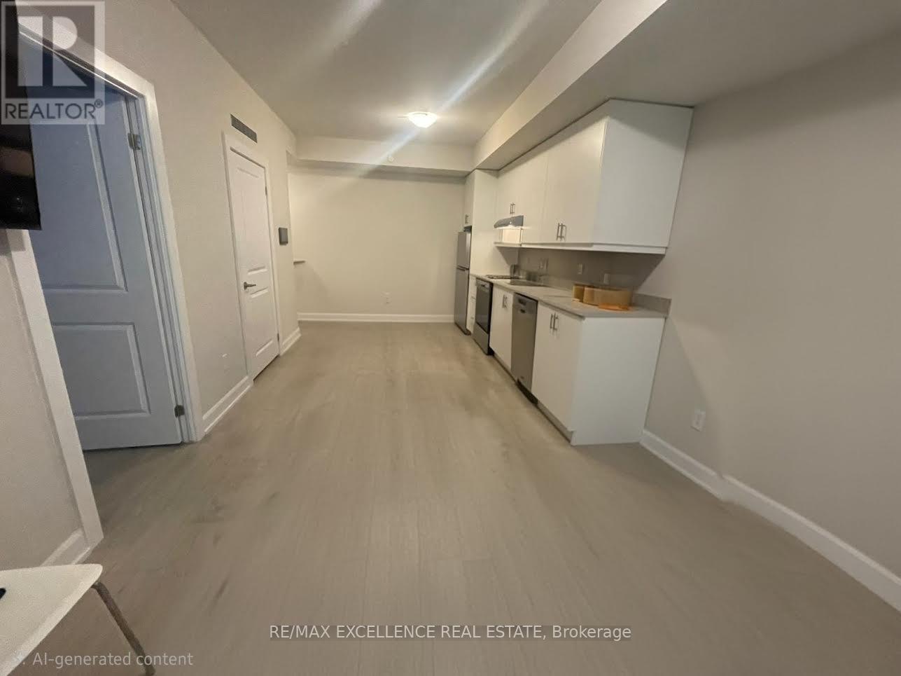 A spacious kitchen area with white cabinets and a wooden floor.