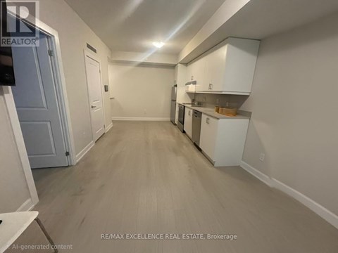 A spacious kitchen area with white cabinets and a wooden floor.