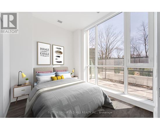 A bedroom with a large bed and a window overlooking a fence.