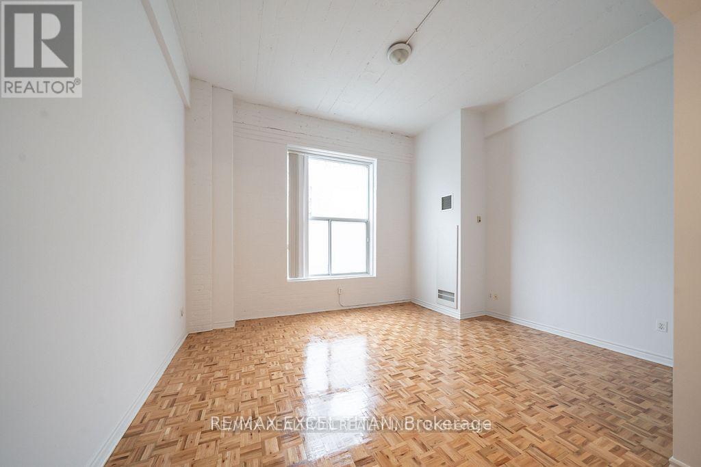 A room with wooden flooring and a window letting in light.