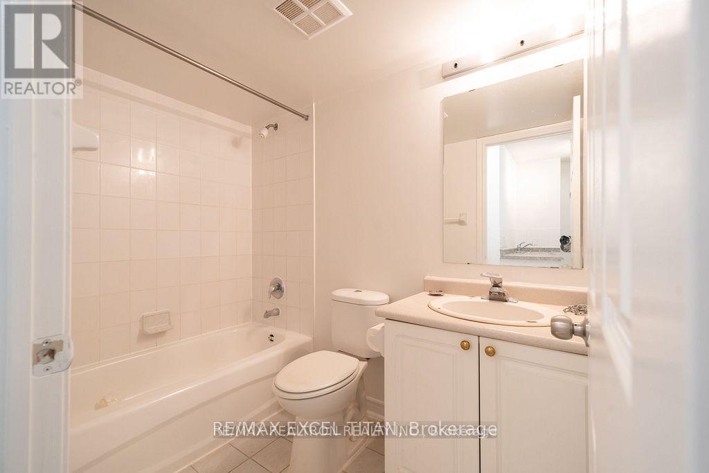 A white bathroom with a toilet, sink, and bathtub.