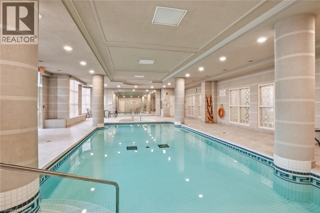 A large indoor swimming pool with a glass enclosure.