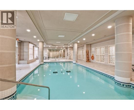 A large indoor swimming pool with a glass enclosure.