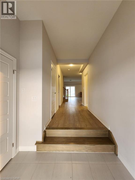 A long hallway with a wooden floor and white walls.