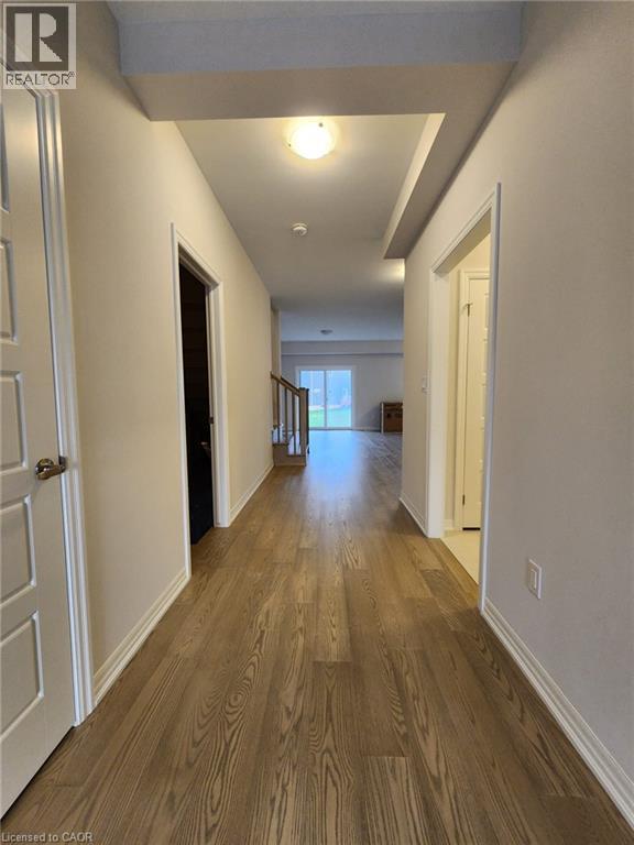 A long hallway with wood floors and white walls.
