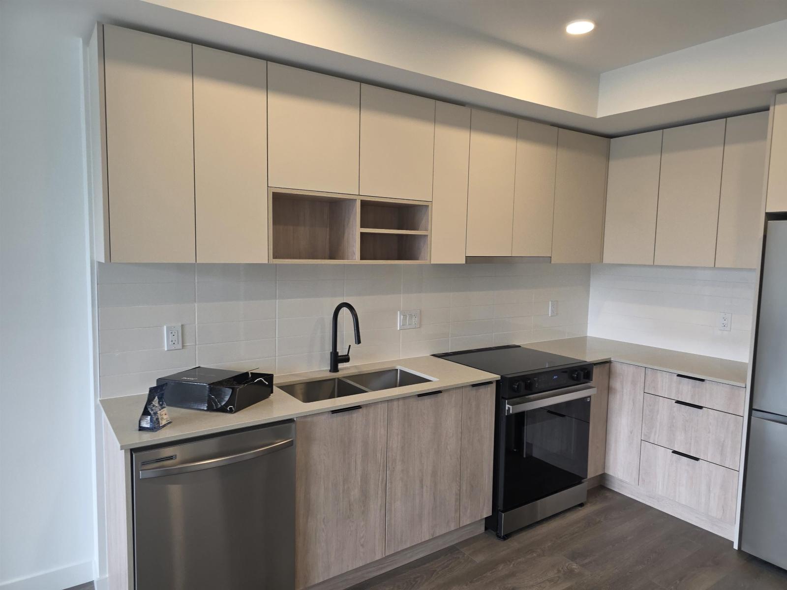 A kitchen with a stainless steel dishwasher and oven.