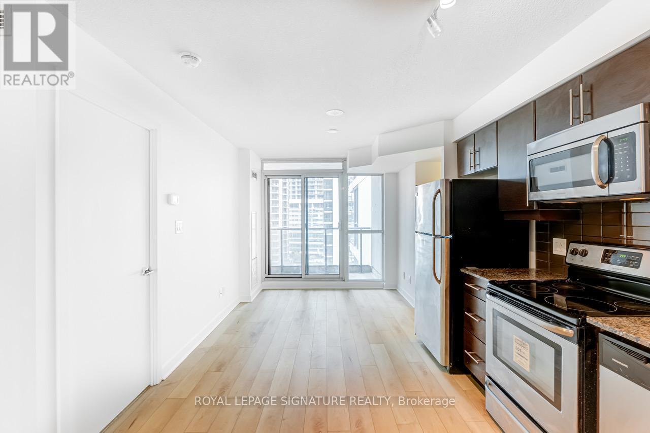 A kitchen with a stove, oven, microwave, and refrigerator.