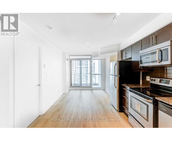 A kitchen with a stove, oven, microwave, and refrigerator.