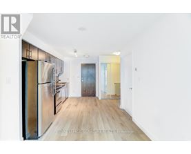 A kitchen with a refrigerator, cabinets, and a countertop.