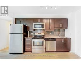 A kitchen with a refrigerator, oven, and microwave.