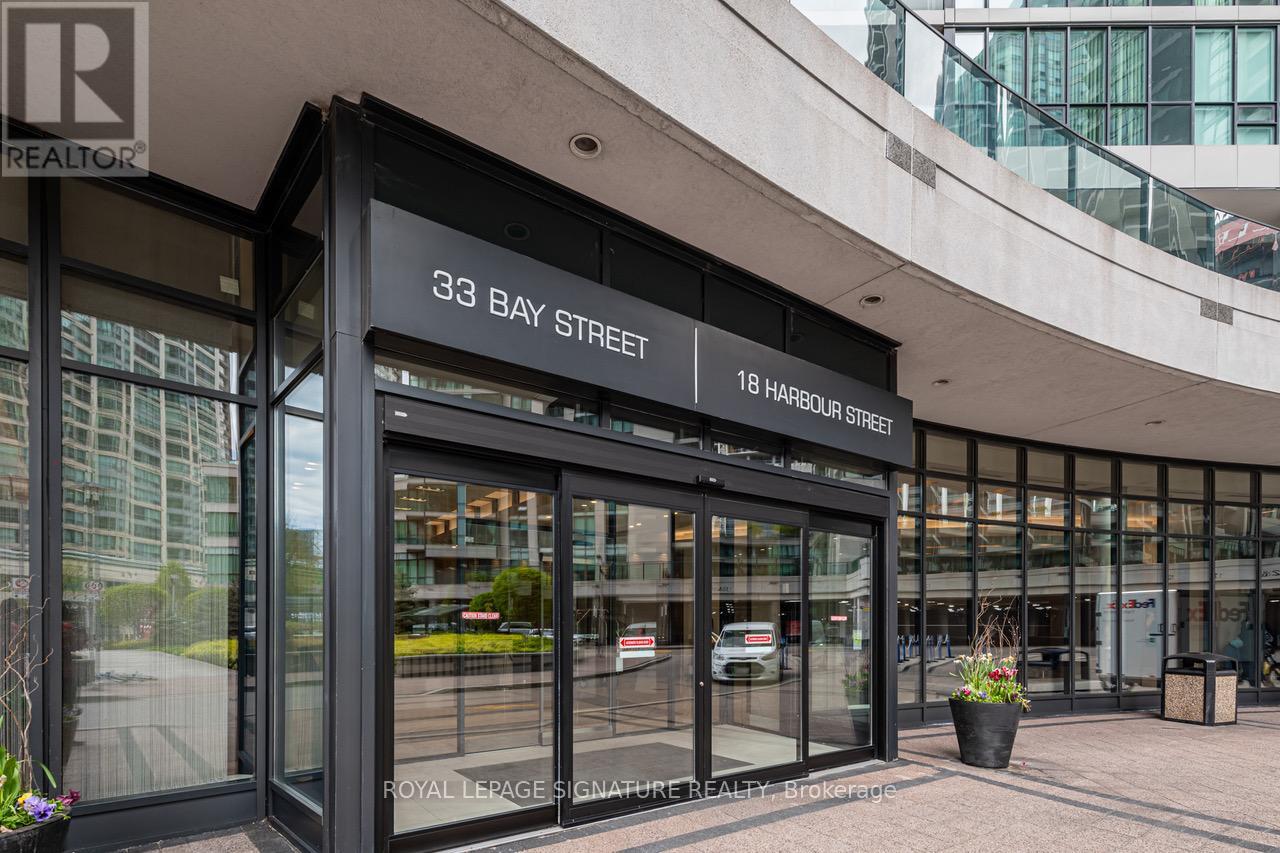 The image shows the front of a building with a glass facade and a sign that reads "33 Bay Street".
