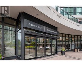 The image shows the front of a building with a glass facade and a sign that reads "33 Bay Street".