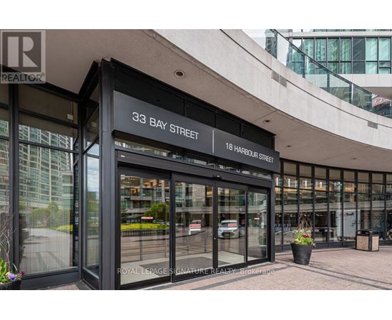 The image shows the front of a building with a glass facade and a sign that reads "33 Bay Street".