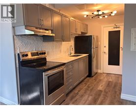 A kitchen with a black stove top oven and a black refrigerator.
