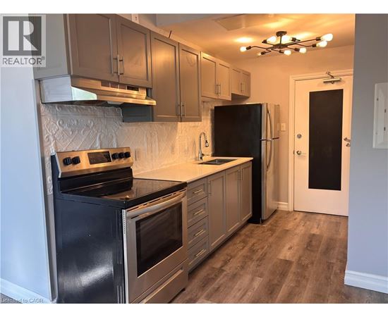 A kitchen with a black stove top oven and a black refrigerator.