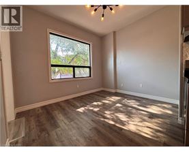 A room with a large window and wooden flooring.