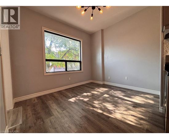 A room with a large window and wooden flooring.