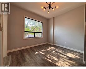 A room with a window and a wooden floor.