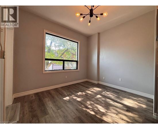 A room with a window and a wooden floor.