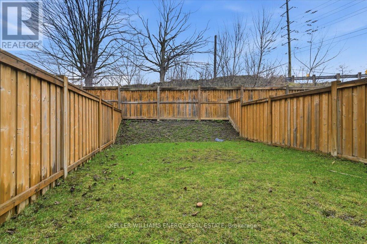 A backyard with a wooden fence and green grass.
