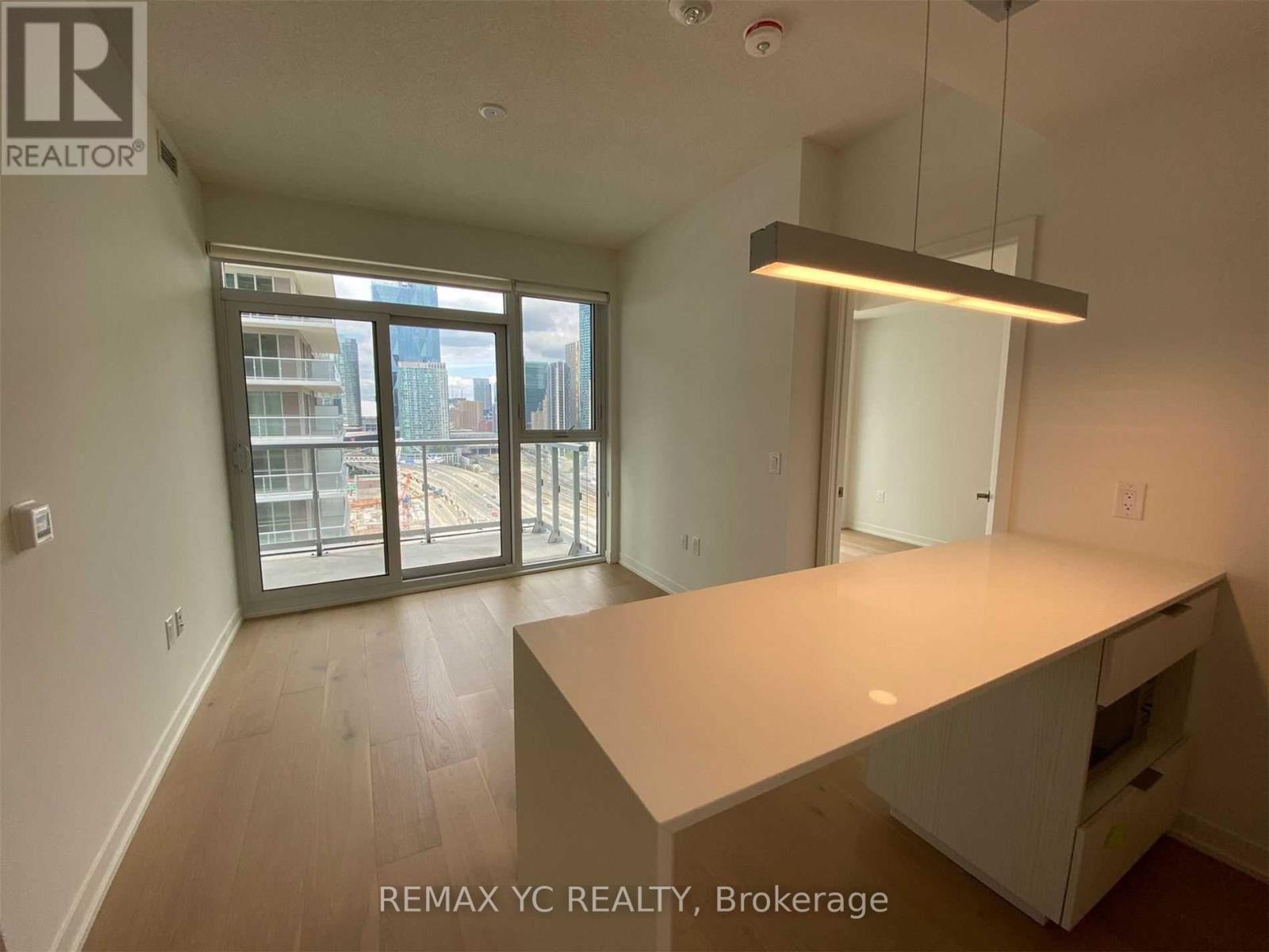 A large, empty room with a desk and a window overlooking a cityscape.
