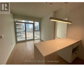 A large, empty room with a desk and a window overlooking a cityscape.