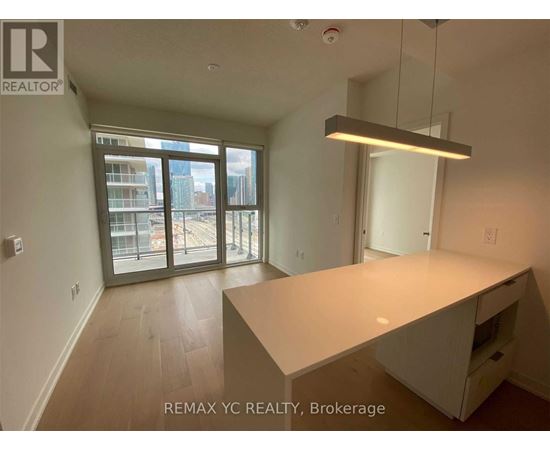 A large, empty room with a desk and a window overlooking a cityscape.