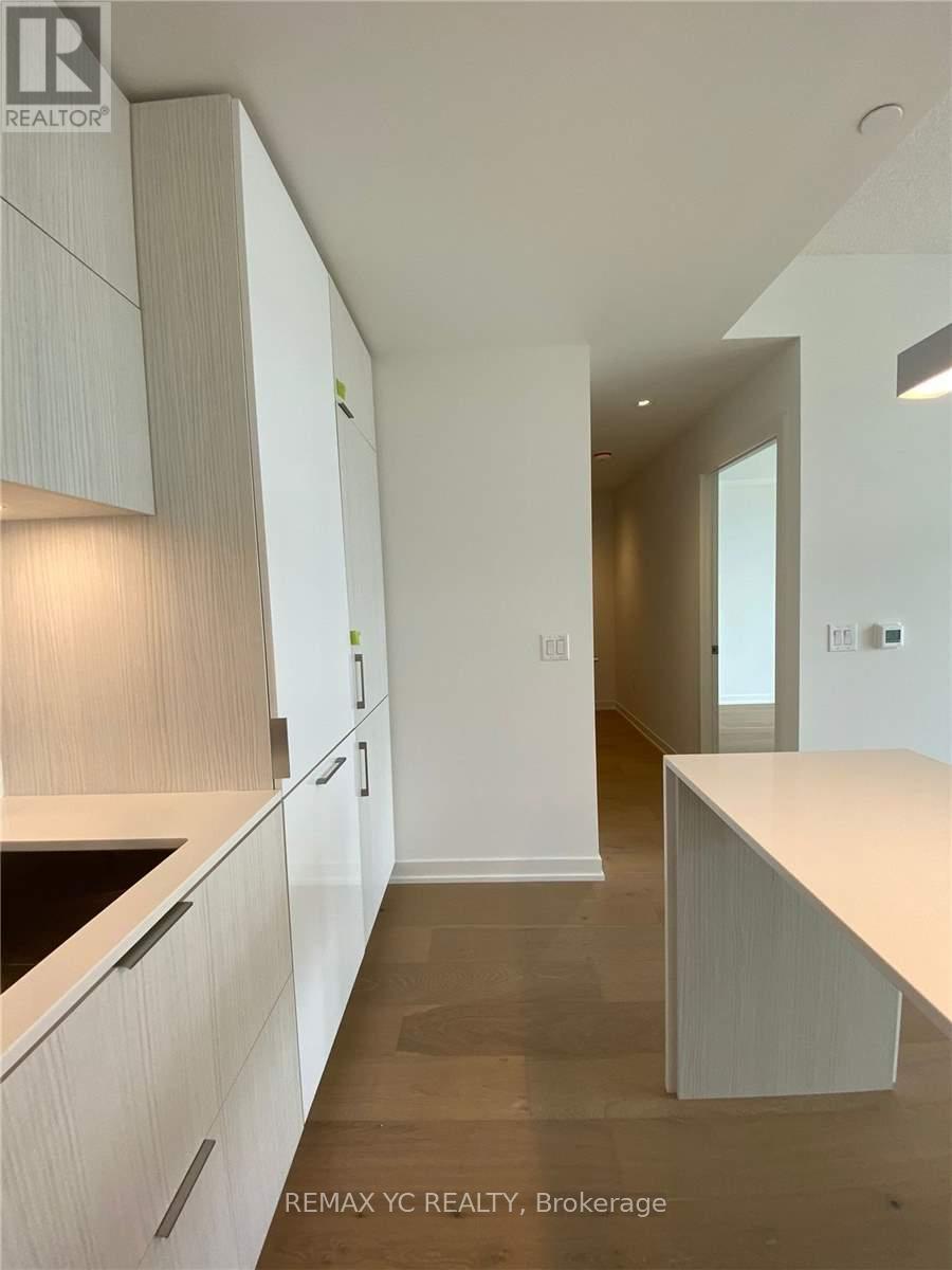 A modern kitchen with white cabinets and a countertop.