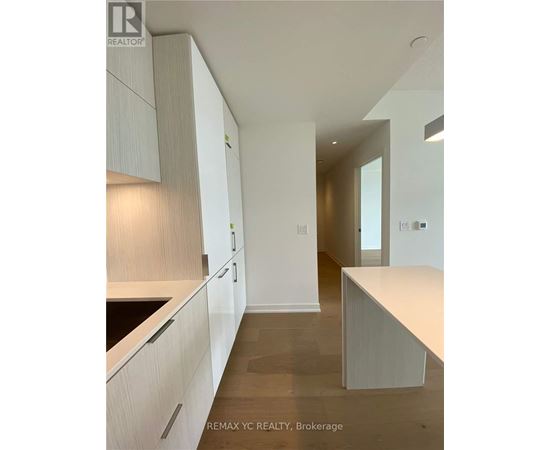 A modern kitchen with white cabinets and a countertop.