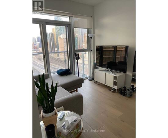 A living room with a large window overlooking a cityscape.