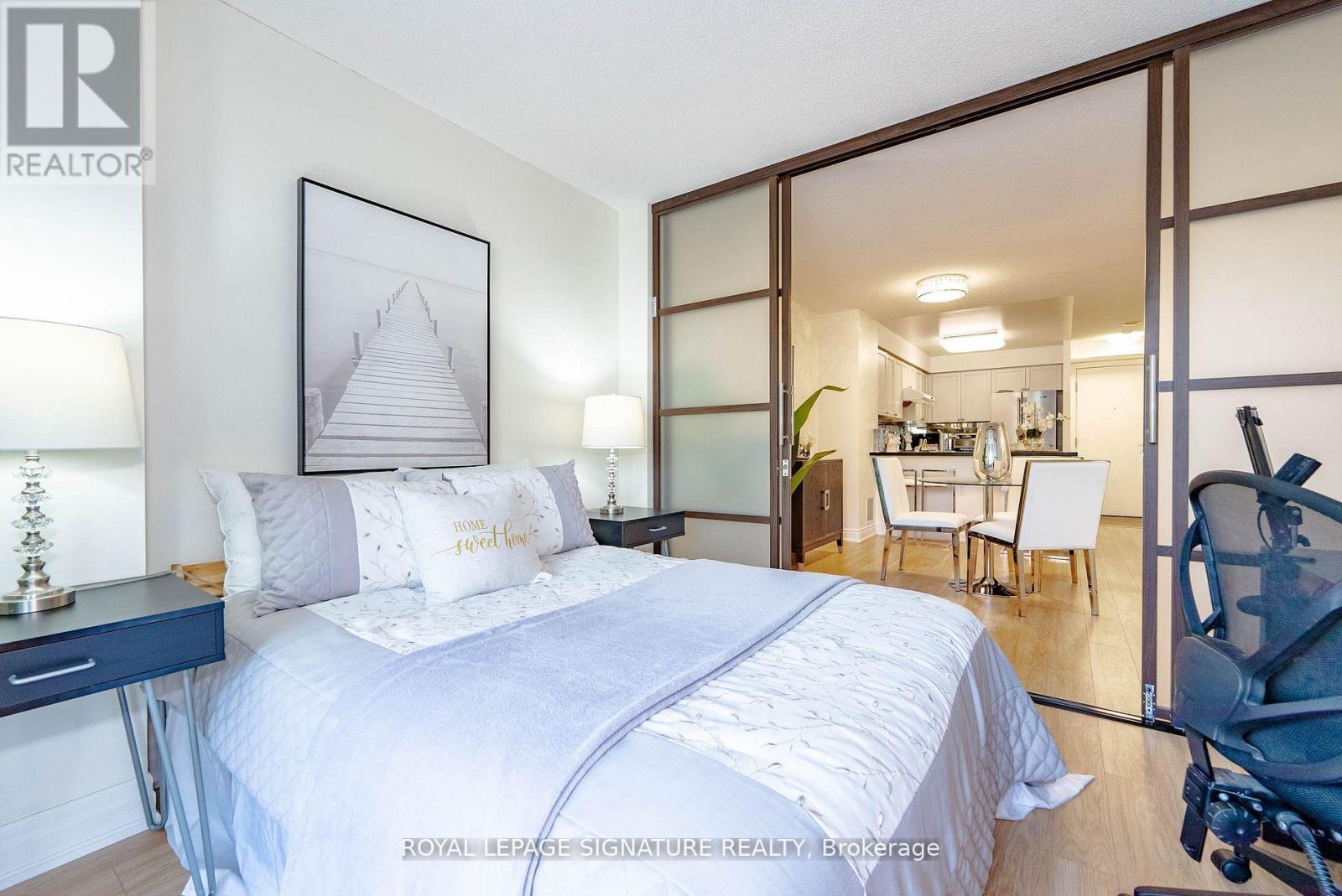 A bedroom with a large bed and a picture of a pyramid on the wall.