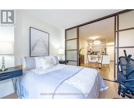 A bedroom with a large bed and a picture of a pyramid on the wall.